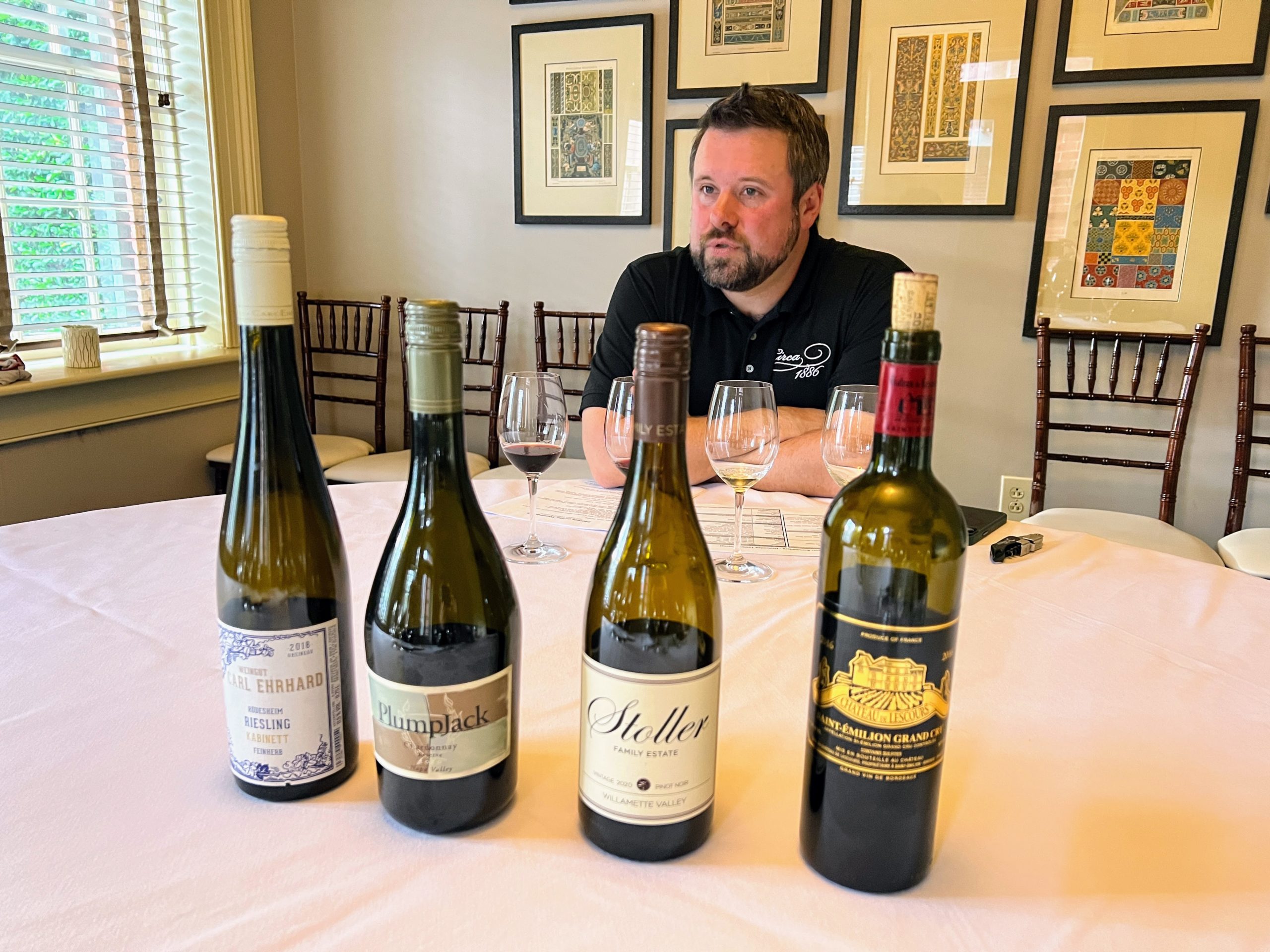 a man sitting at a table with wine bottles