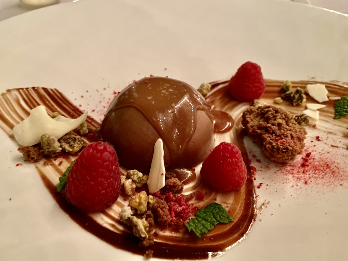 a plate of dessert with chocolate and raspberries