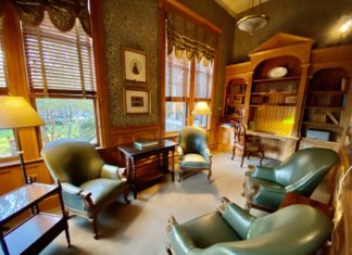 a room with green chairs and a bookcase