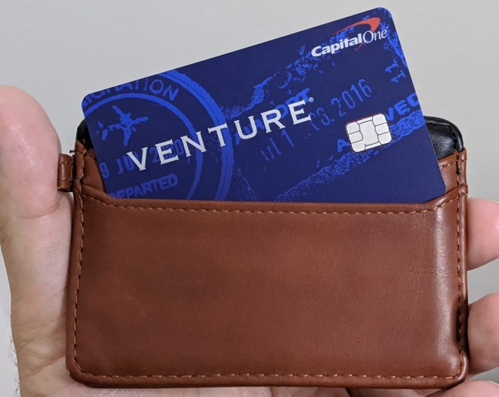 a hand holding a wallet with a credit card in it