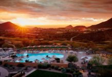 a pool with umbrellas and chairs in a resort