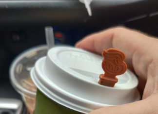 a hand holding a coffee cup