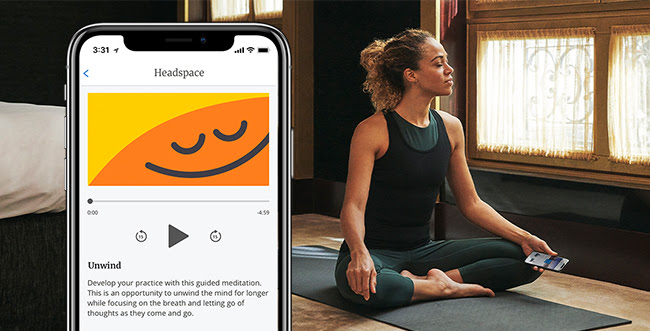 a woman sitting on a yoga mat and a phone