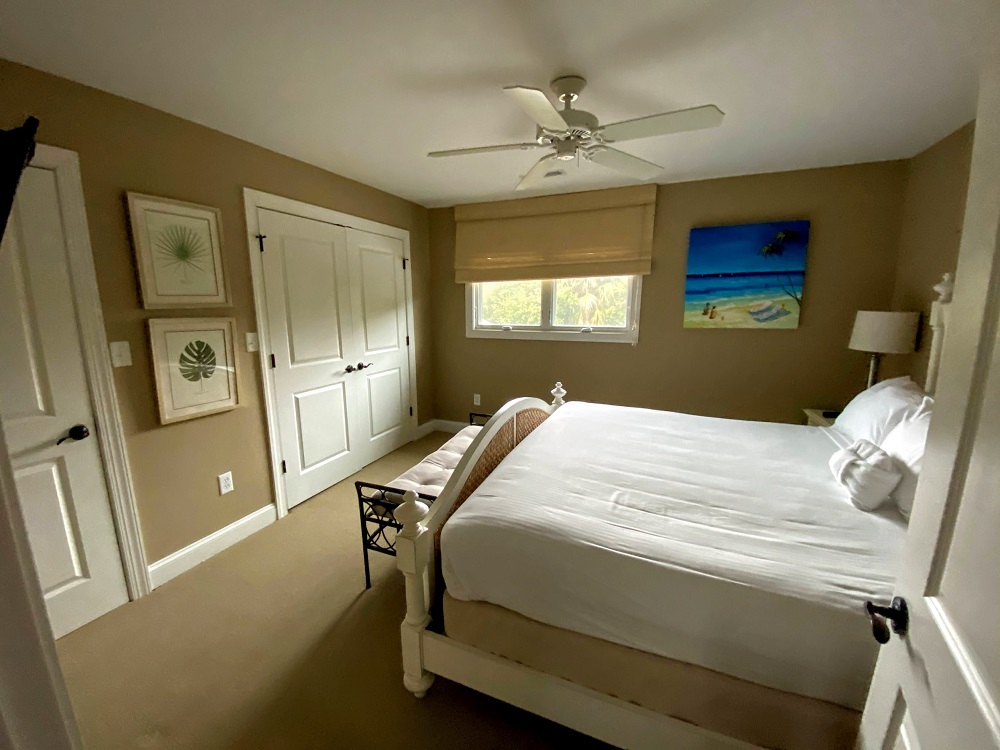 a bedroom with a white bed and a fan