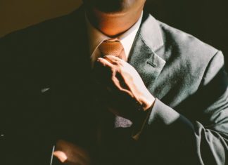 a man in a suit fixing his tie