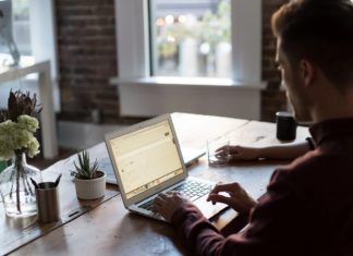 a man sitting at a table using a laptop