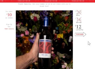 a hand holding a bottle of wine