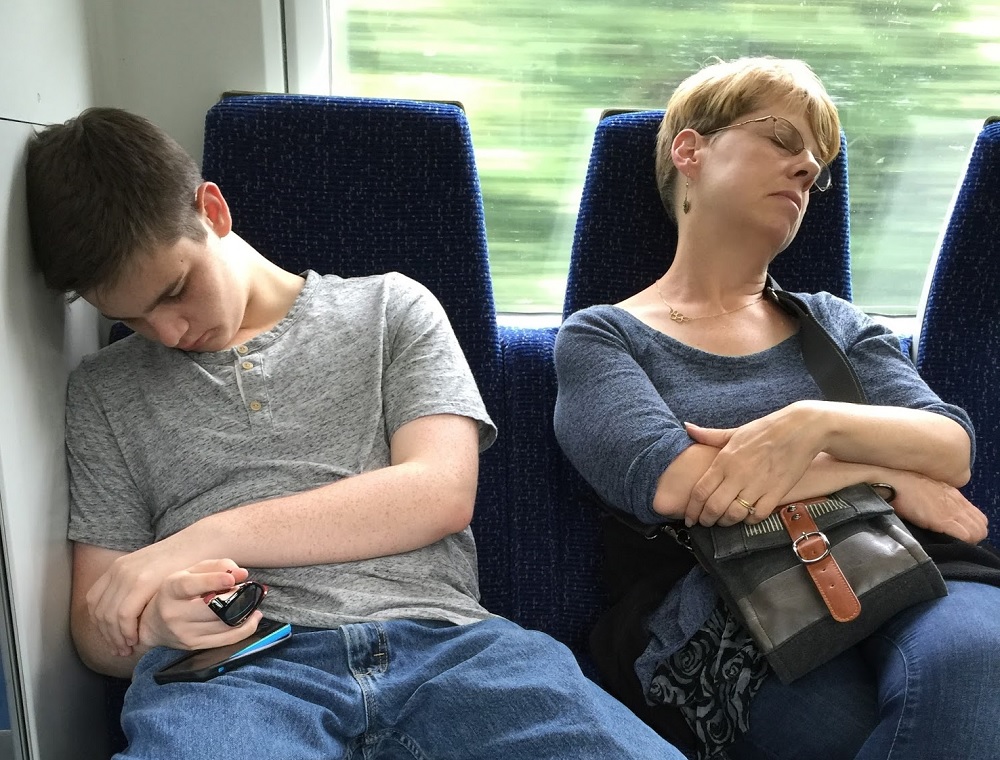 a man and woman sleeping on a train
