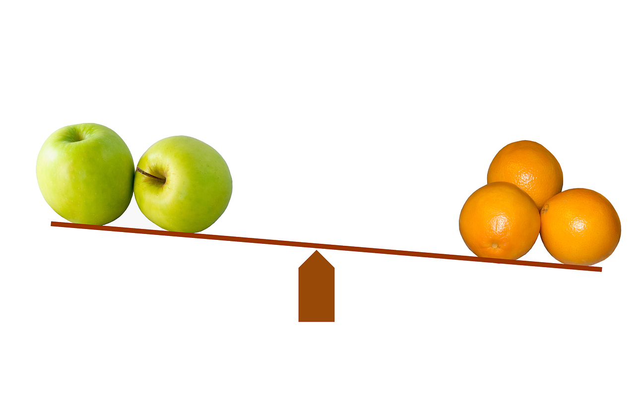 a green apples and oranges on a balance