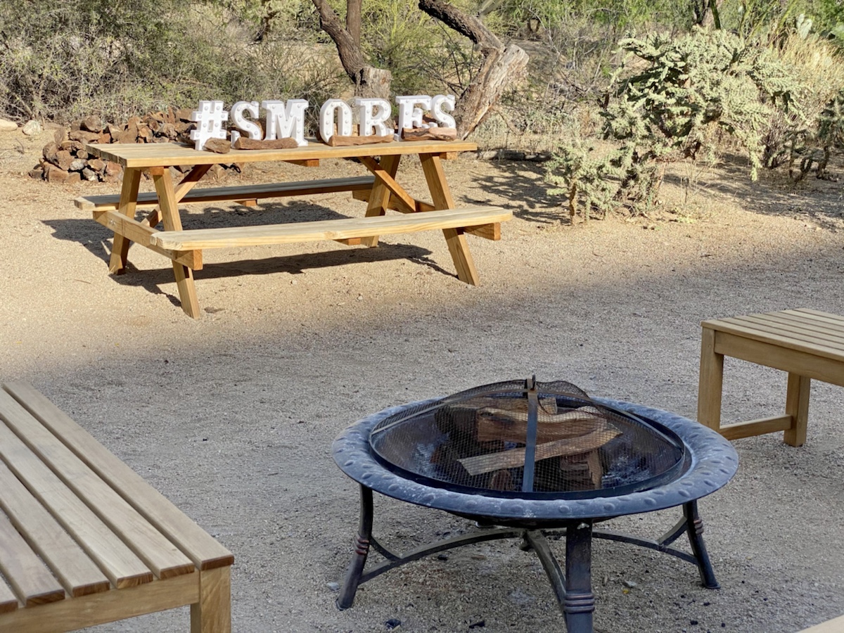 a picnic table with a fire pit and benches