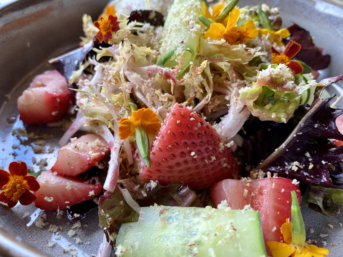 a salad with strawberries and vegetables