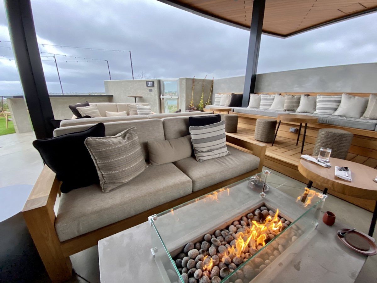 a patio with a fire pit and couches