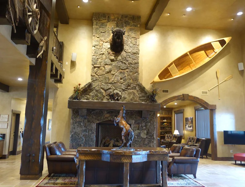 a room with a fireplace and a table and a sculpture of a buffalo