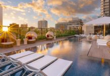 a pool with chairs and a roof top