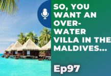 a group of houses with thatched roofs over water