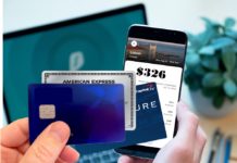 a hand holding a cell phone and a credit card