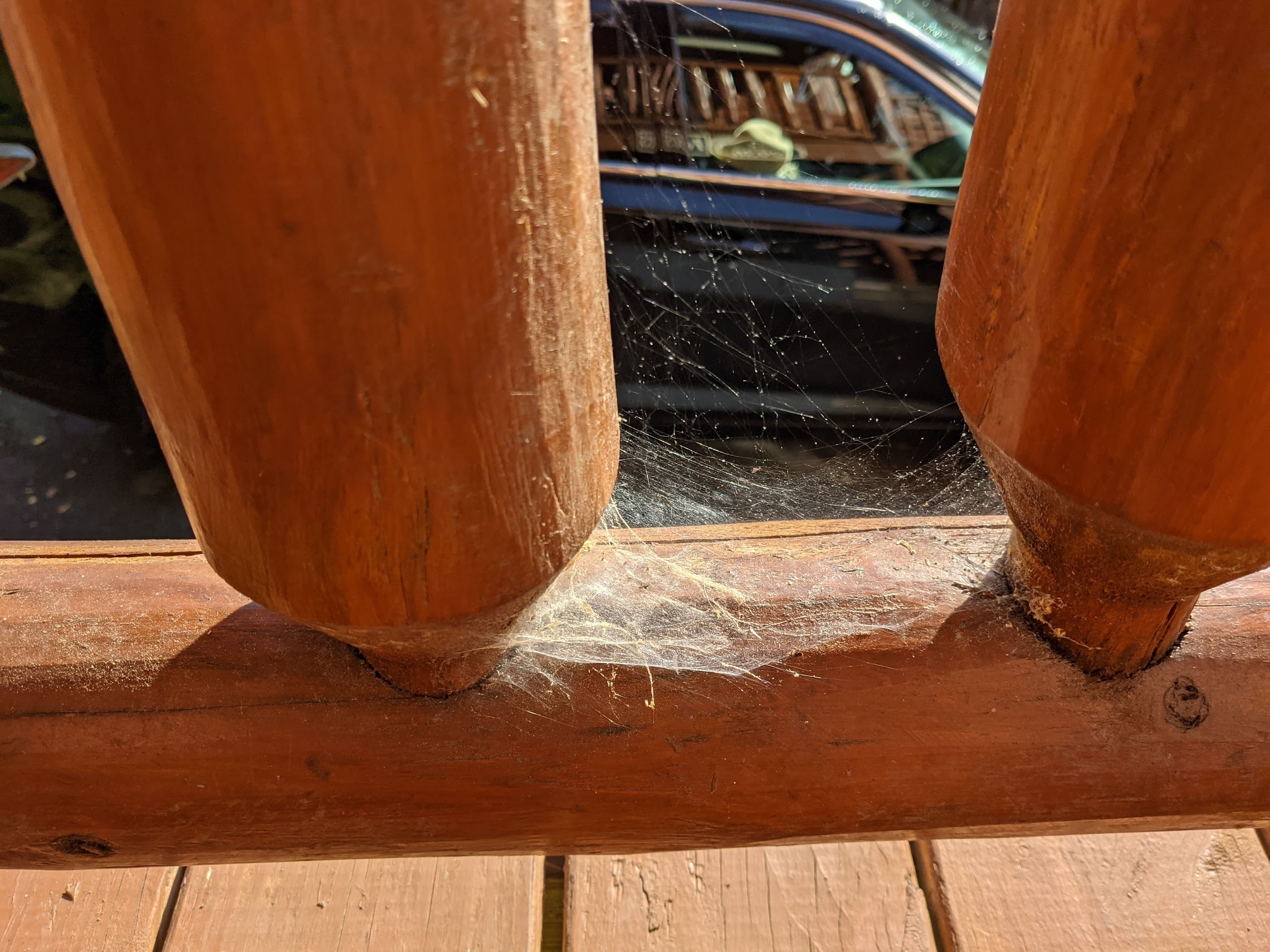a wooden railing with a spider web on it