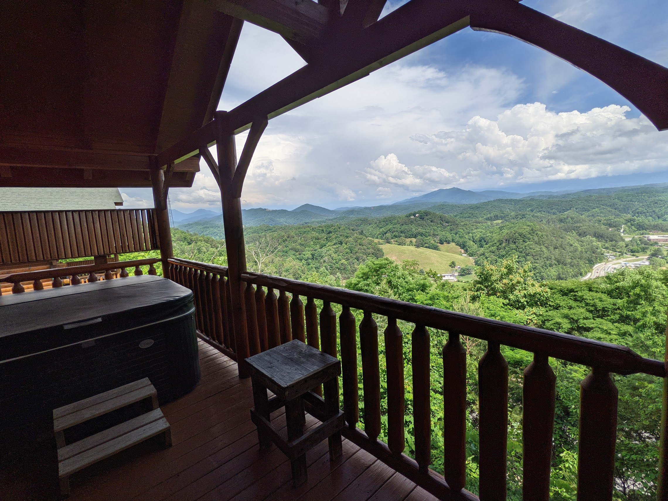 a deck with a view of the mountains and trees