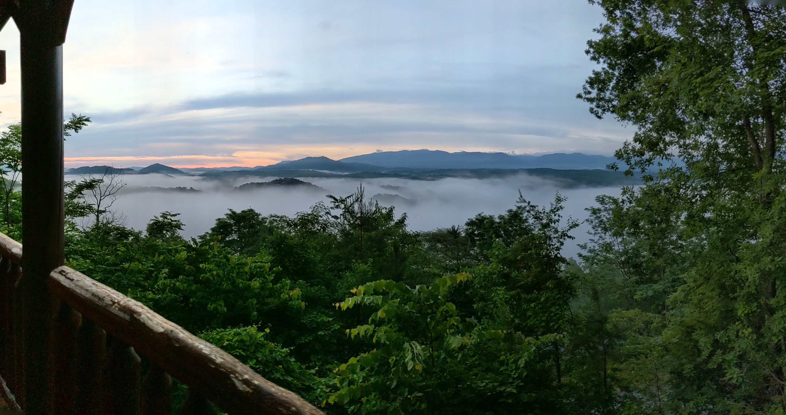 a view of a foggy valley from a balcony