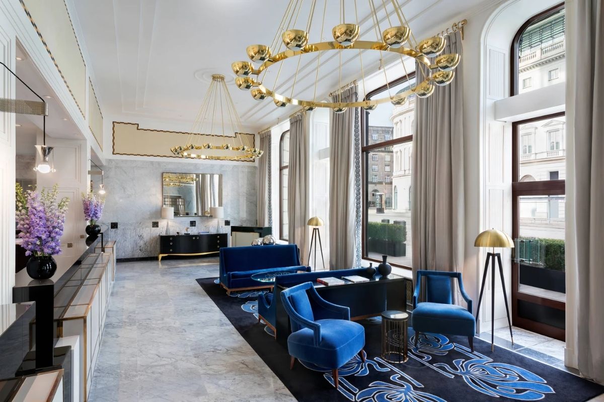 a room with blue furniture and gold chandeliers