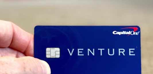 a hand holding a blue credit card