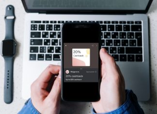 a person holding a phone with a laptop in the background