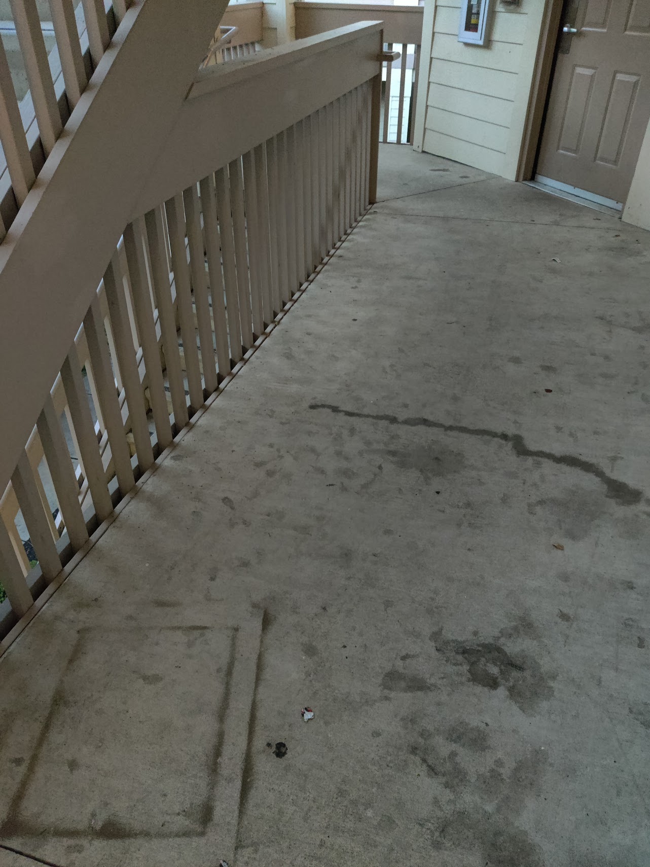 a concrete floor with a white railing