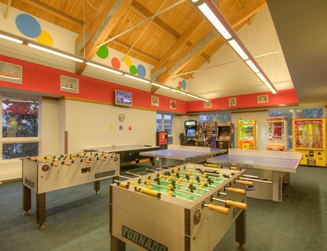 a room with foosball tables and arcade games