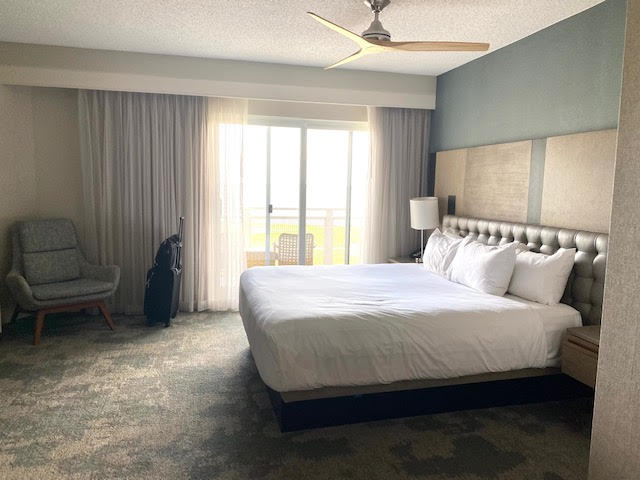 a hotel room with a large bed and a ceiling fan
