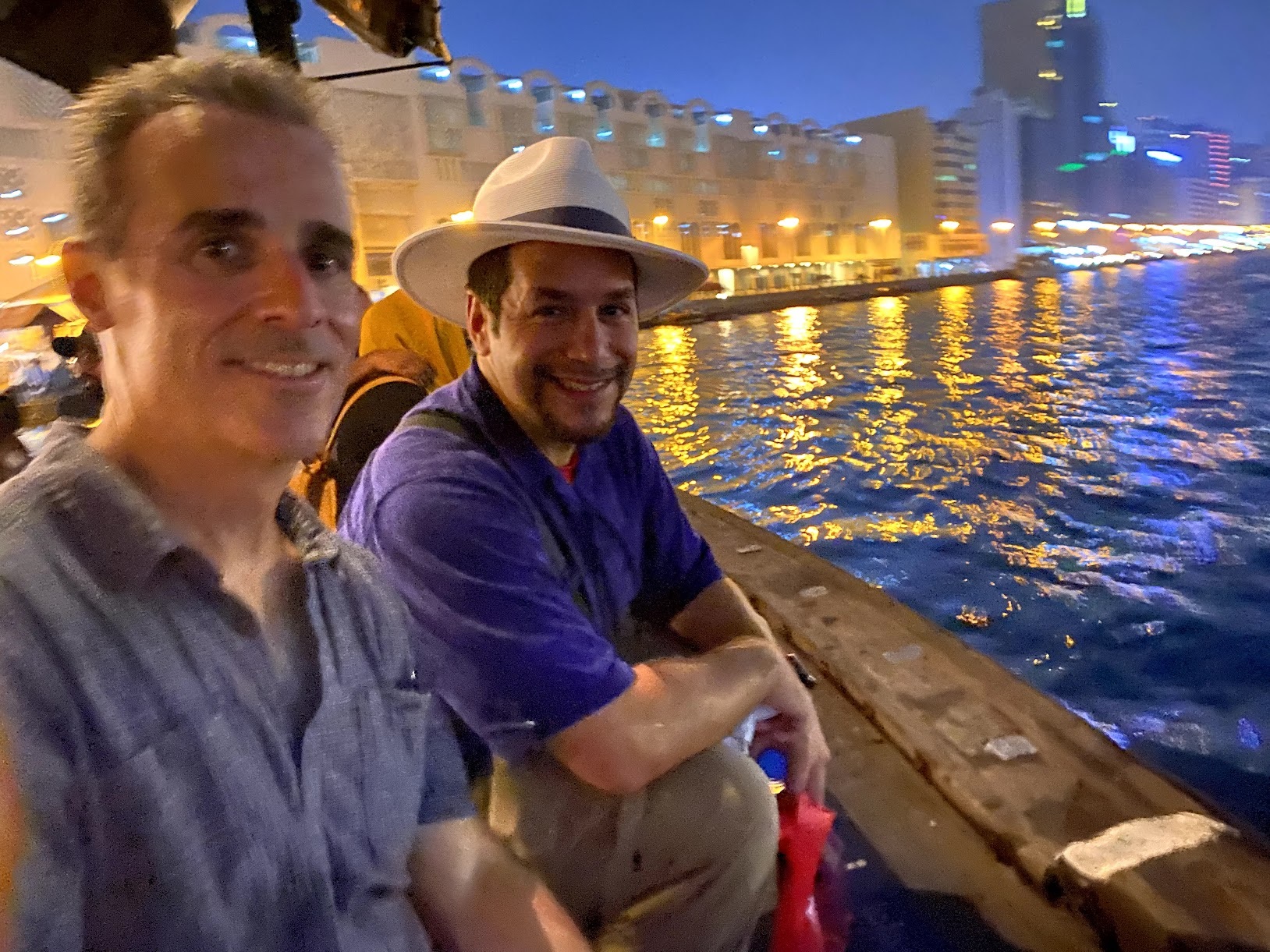 two men sitting on a boat in the water