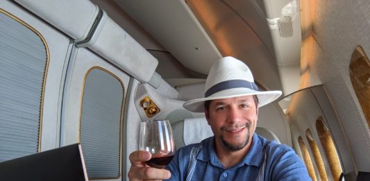 a man sitting at a desk with a glass of wine