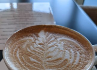 a cup of coffee with a leaf design in the foam