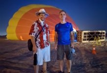 two men standing in front of a hot air balloon