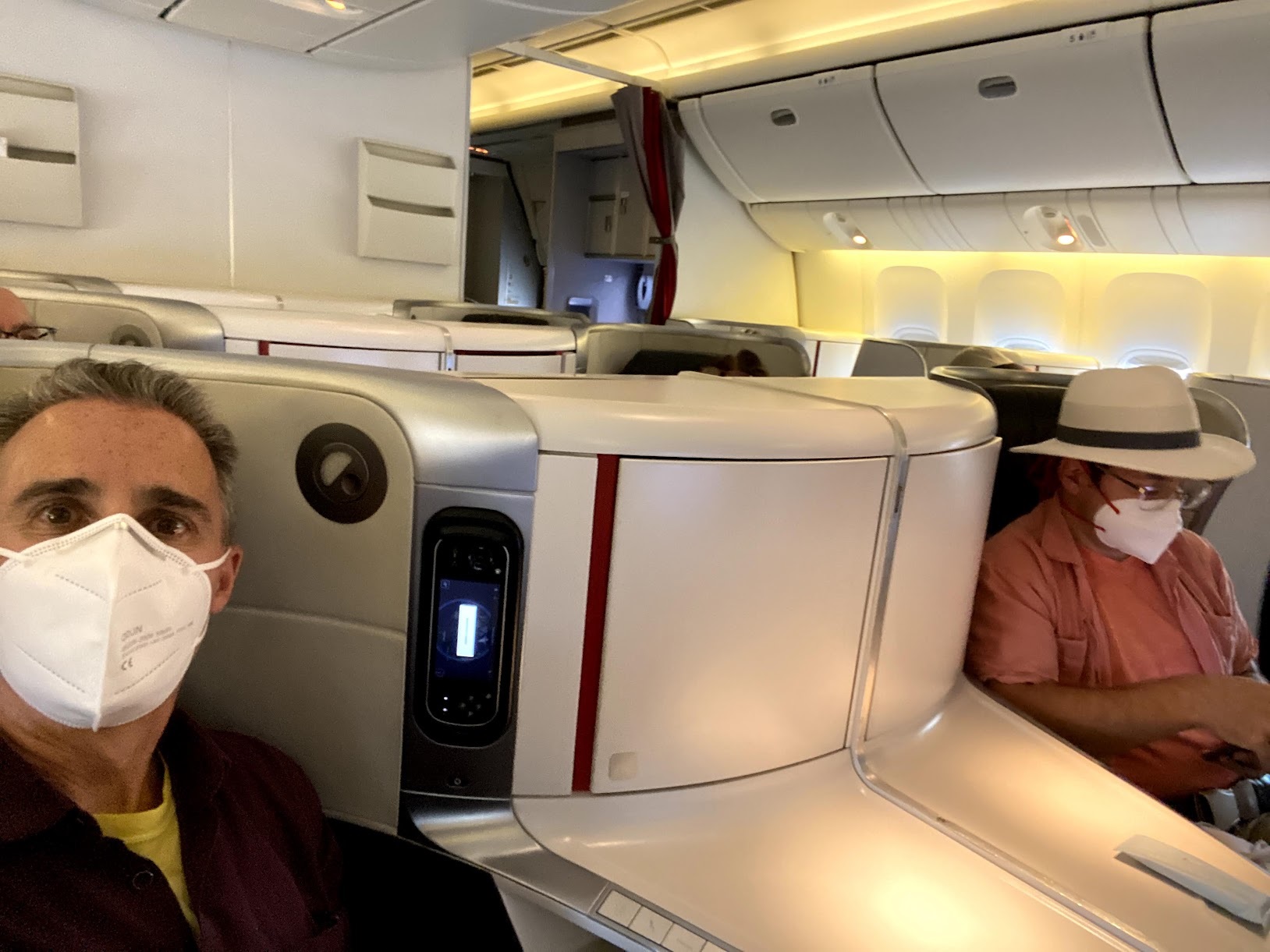 a man sitting in a plane with a mask on his face
