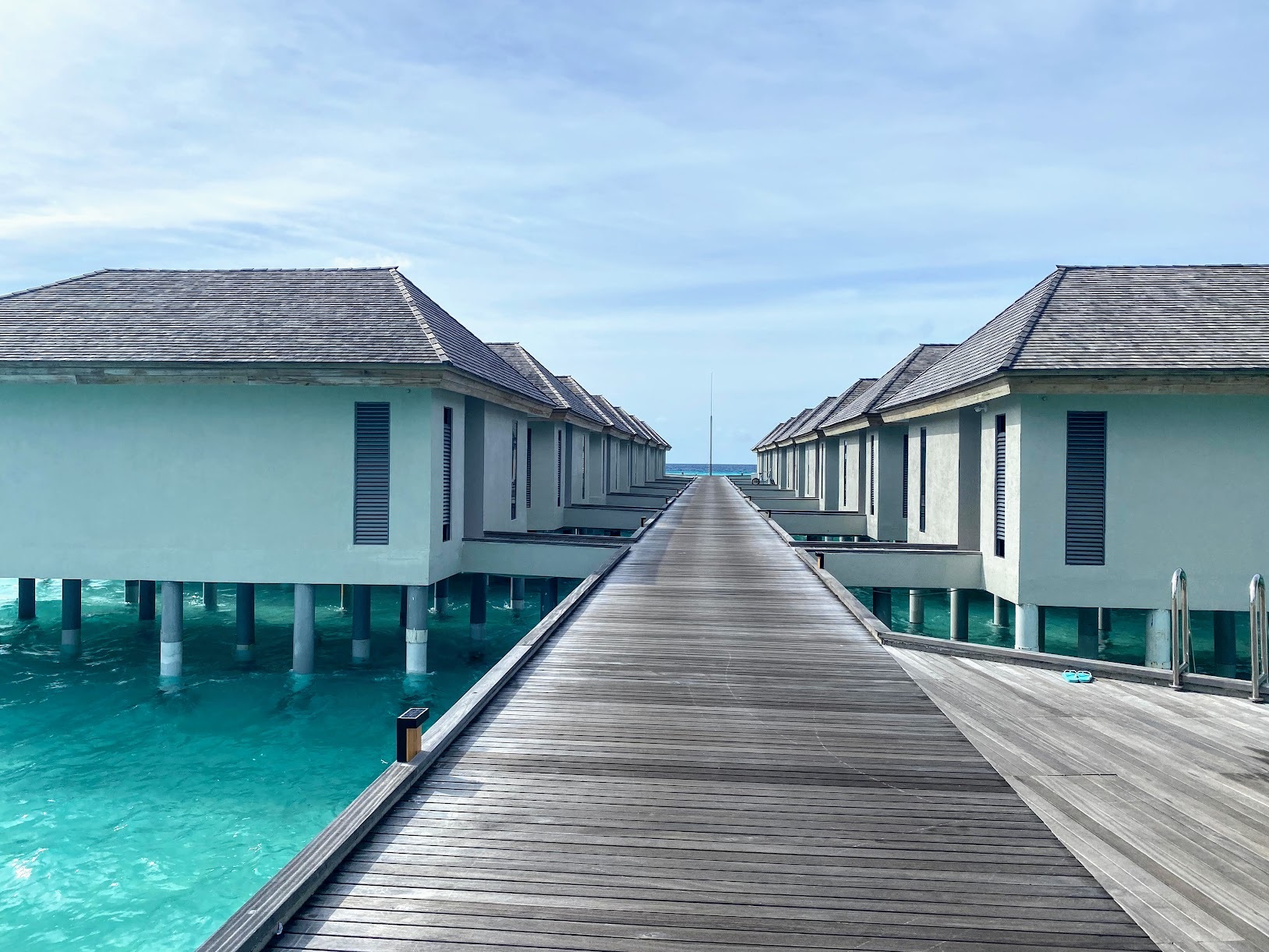 a long walkway leading to a row of houses on stilts