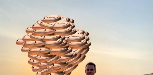 a man holding up a large pile of coins