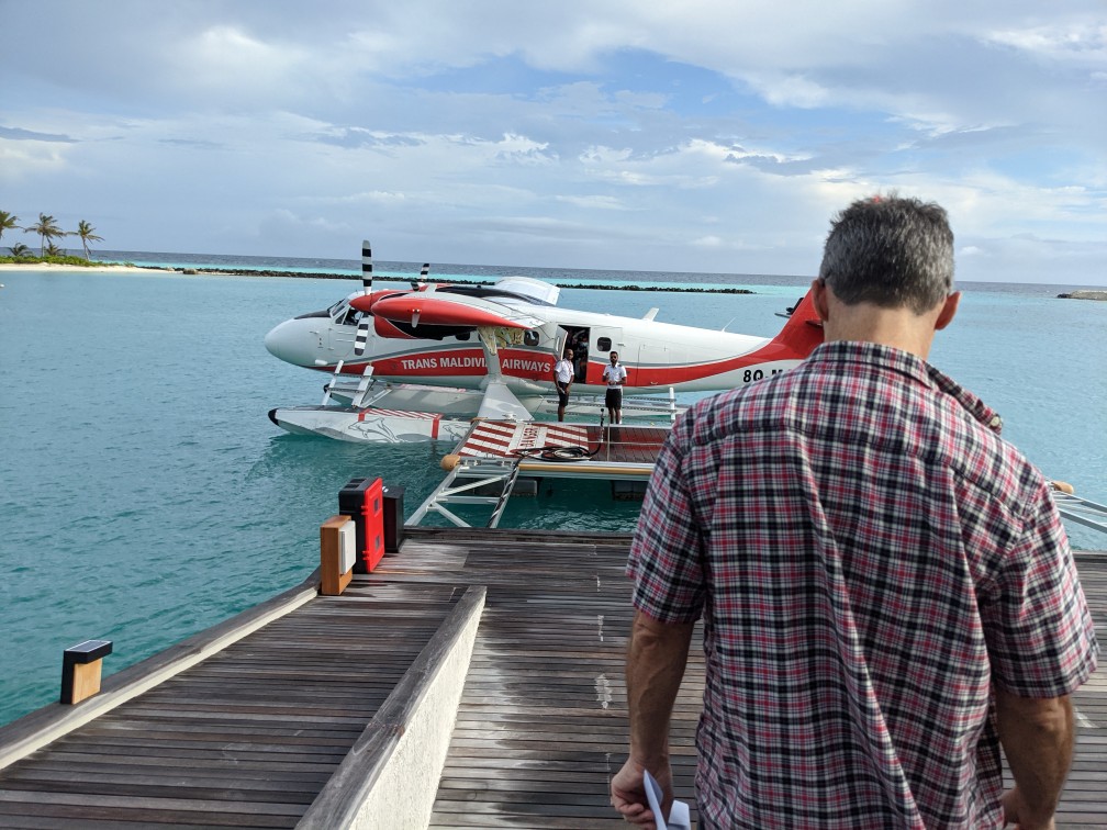 a man standing on a dock with a plane in the water