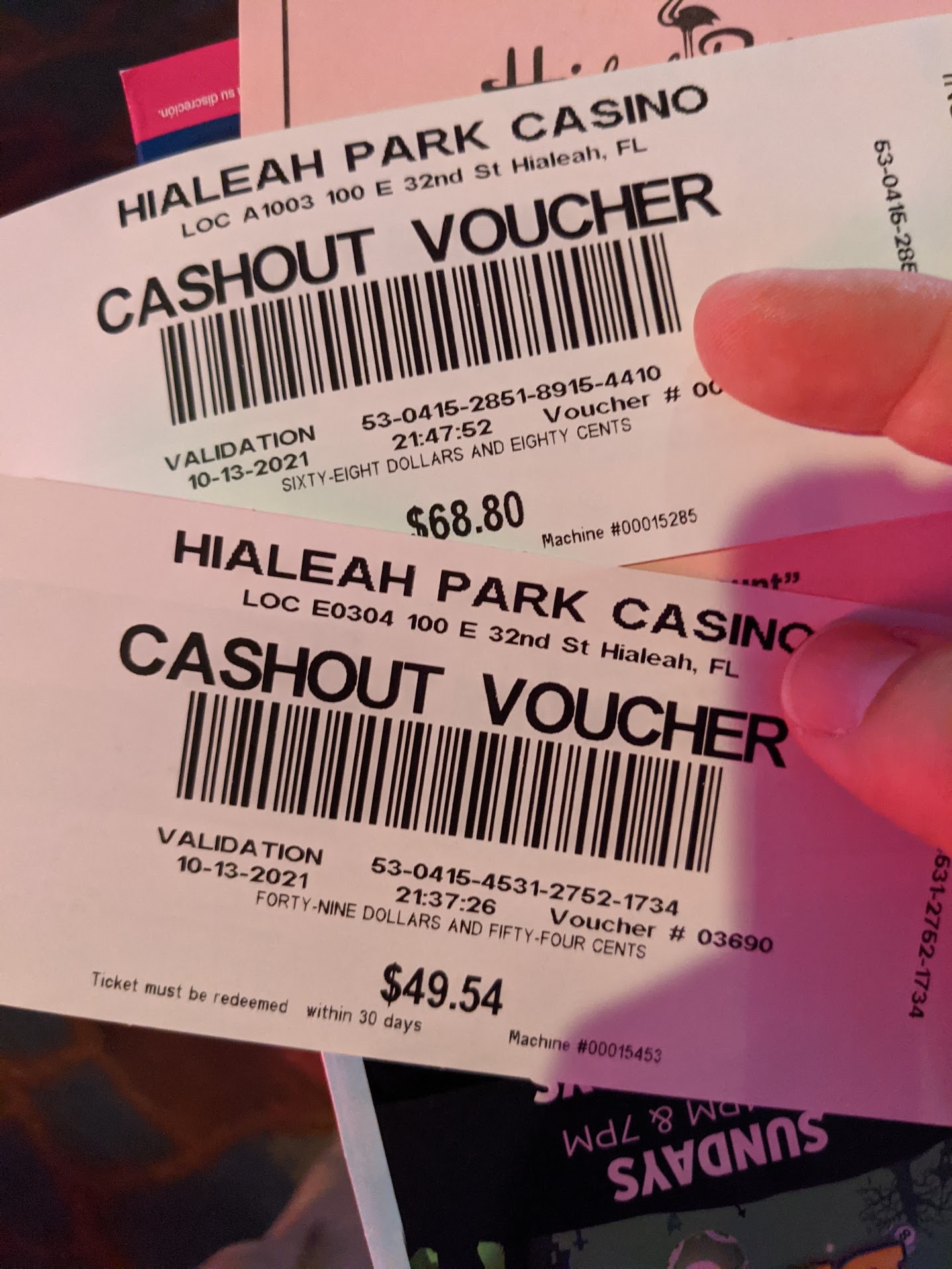 a hand holding a pair of cashout vouchers