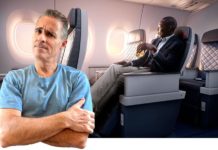 a man standing in an airplane with a man sitting in a chair