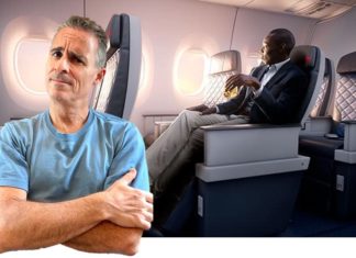 a man standing in an airplane with a man sitting in a chair