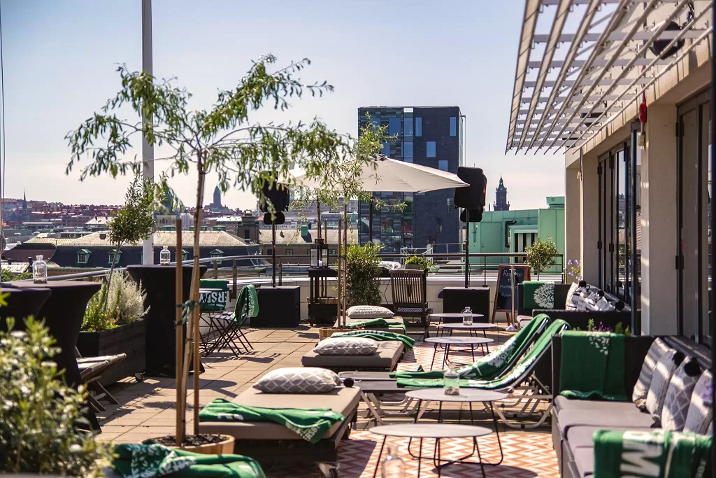 a patio with chairs and tables on a rooftop