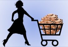 a silhouette of a woman pushing a cart full of coins