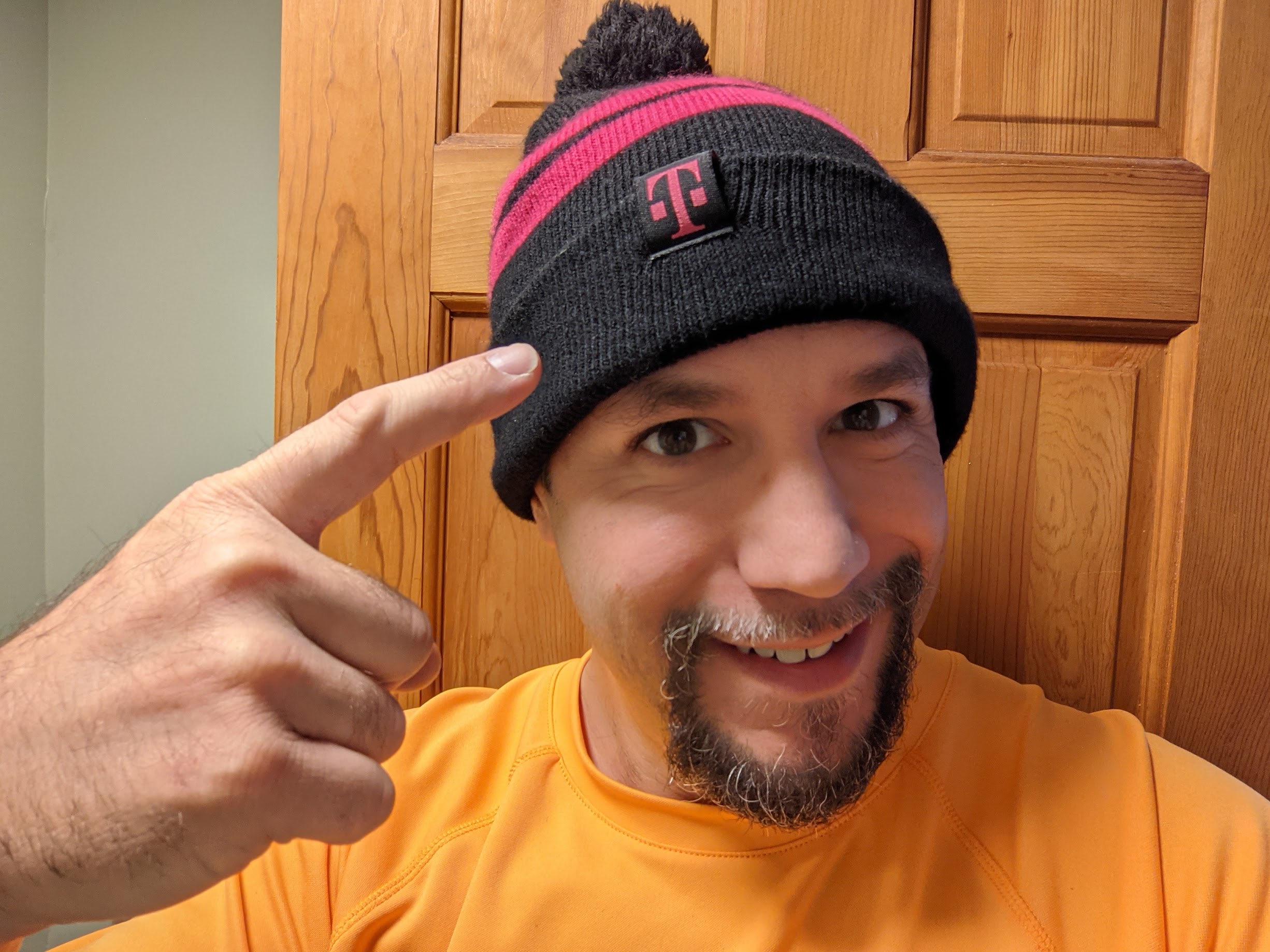 a man wearing a beanie and pointing his finger