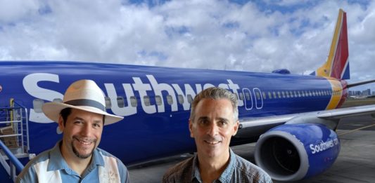 two men standing in front of a plane