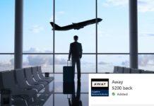 a man standing in an airport with a suitcase