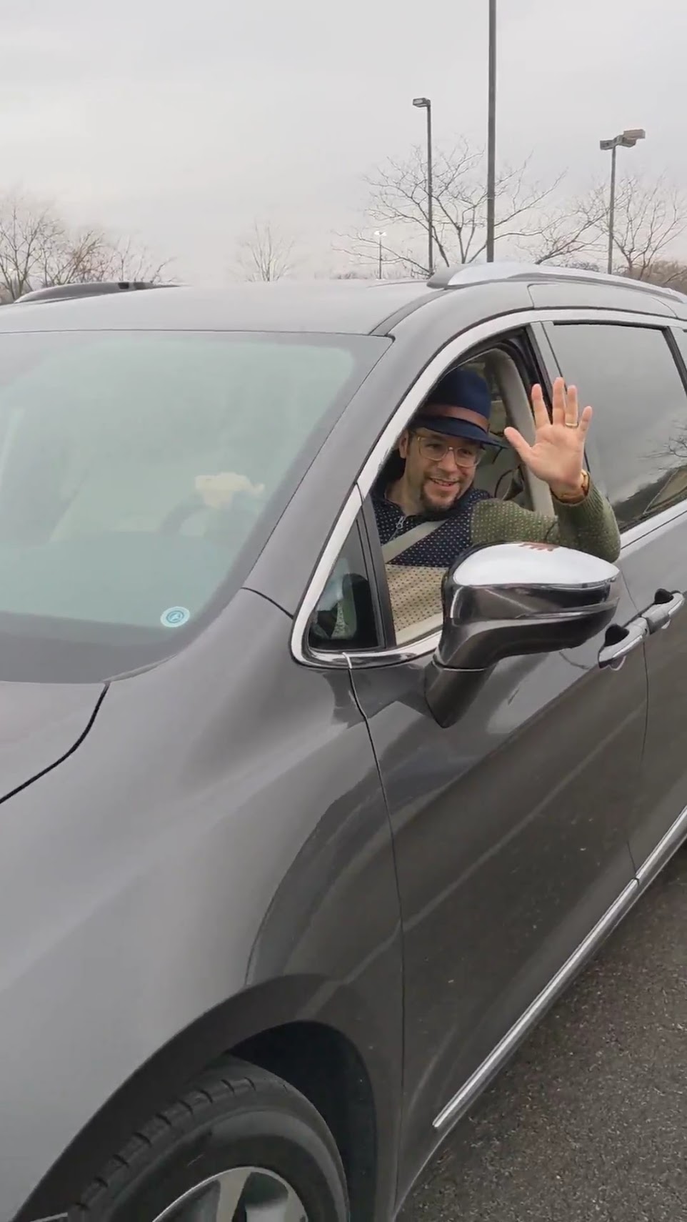 a man waving from a car