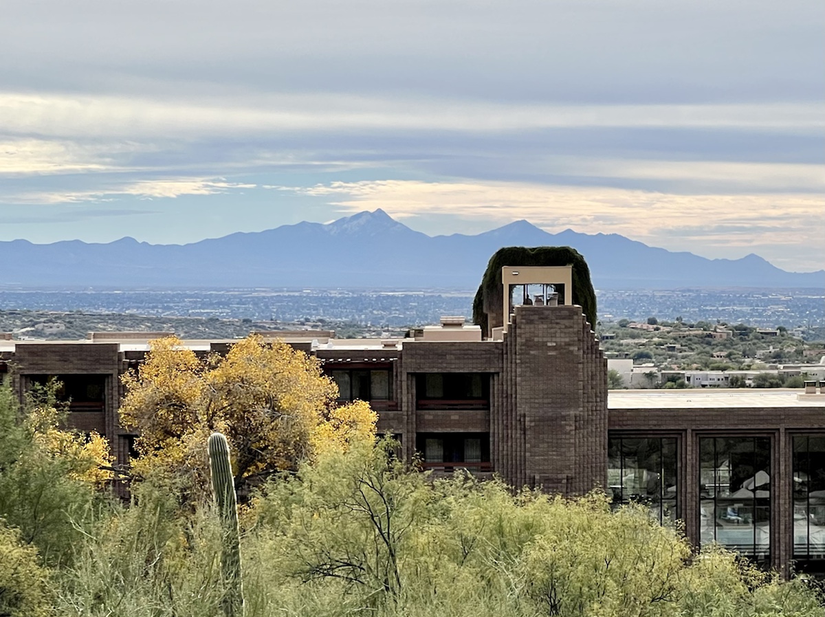 a building with trees and mountains in the background