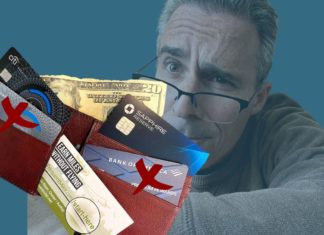 a man holding a wallet with credit cards