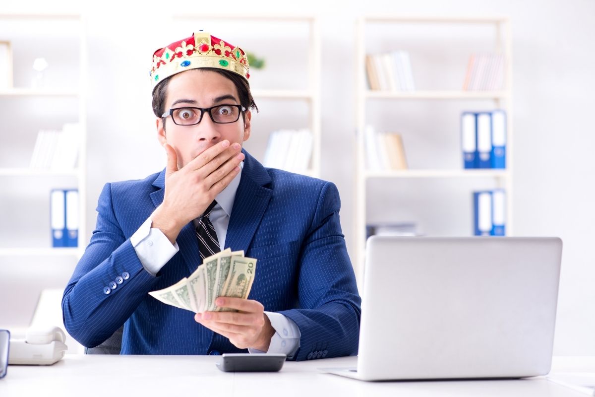 a man wearing a crown holding money