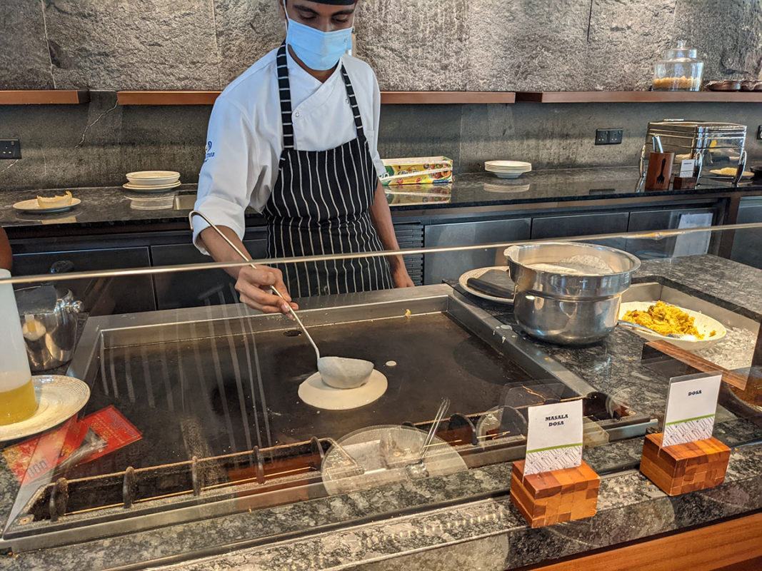 a person wearing a face mask cooking food